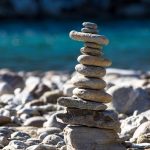 A stack of pebbles on a beach balancing to represent a balanced approach to governance
